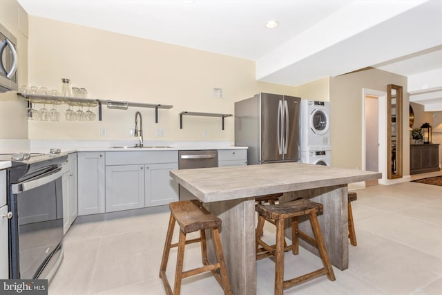 4083 Reels Mill Rd, Frederick, MD 21704 - kitchen with stacked washer / drying machine, stainless steel appliances, a sink, light tile patterned flooring, and a kitchen breakfast bar