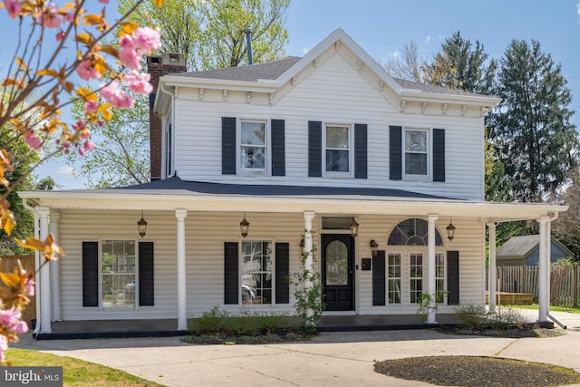 view of front of house featuring covered porch and a chimney