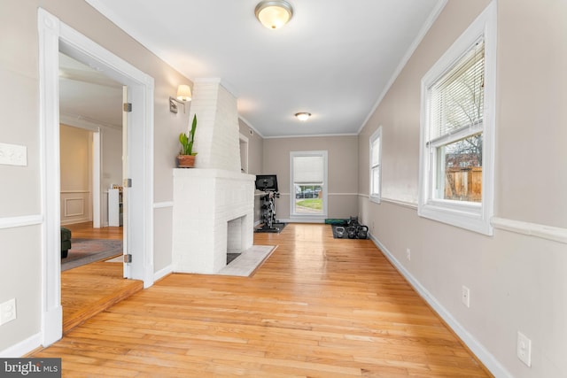 hallway featuring light wood-style flooring and ornamental molding