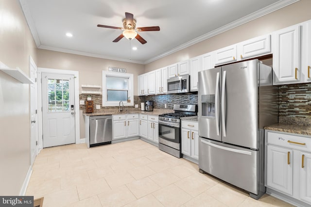 kitchen featuring ceiling fan, light stone countertops, a sink, stainless steel appliances, and decorative backsplash