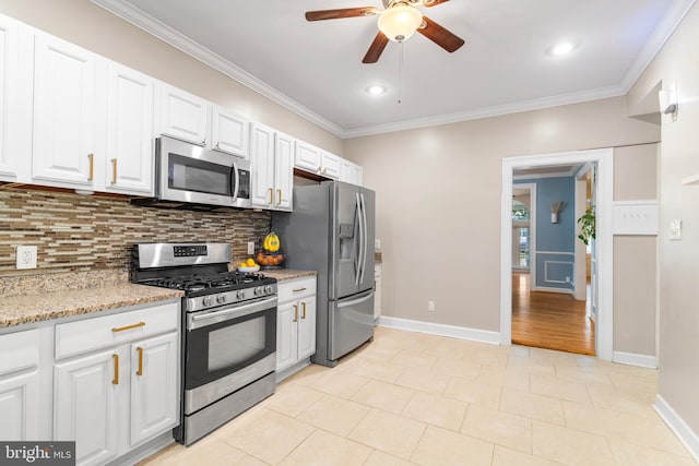 kitchen with backsplash, crown molding, white cabinets, ceiling fan, and appliances with stainless steel finishes