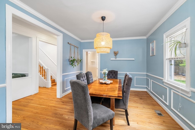 dining area featuring crown molding and light wood-style flooring