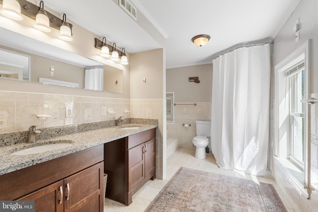 bathroom with toilet, a sink, visible vents, and tile walls