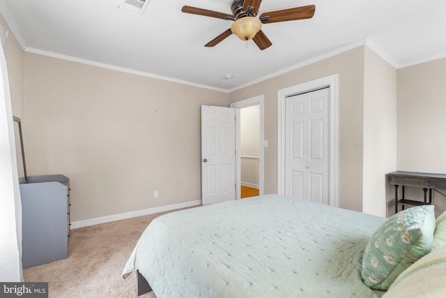 carpeted bedroom featuring a closet, visible vents, baseboards, and crown molding