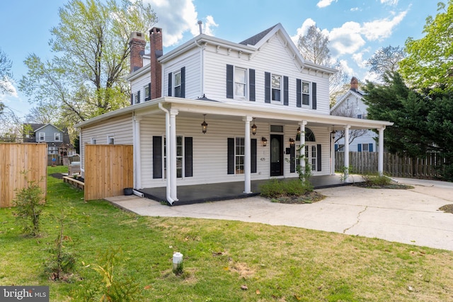 view of front of home featuring a front lawn, fence, covered porch, and a chimney