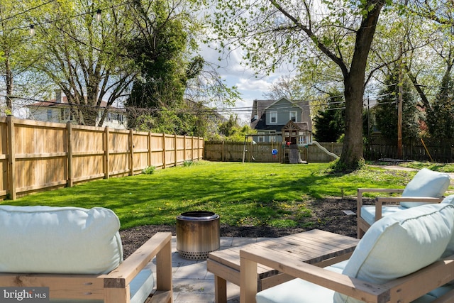 view of yard featuring a fenced backyard, a playground, a patio, and an outdoor hangout area