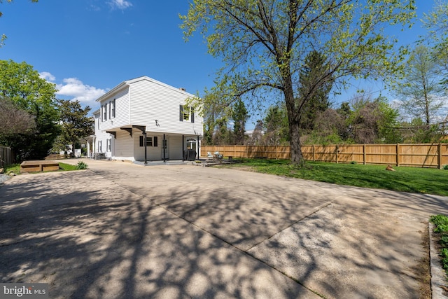 view of home's exterior featuring fence and a lawn