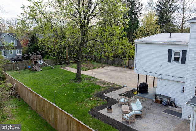 view of yard with a patio area, a fenced backyard, and a playground