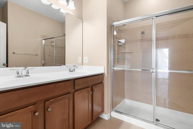 full bath featuring tile patterned flooring, a sink, double vanity, and a stall shower