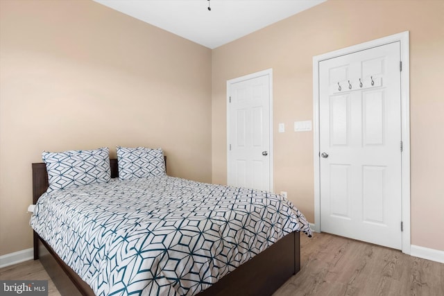 bedroom featuring baseboards and wood finished floors