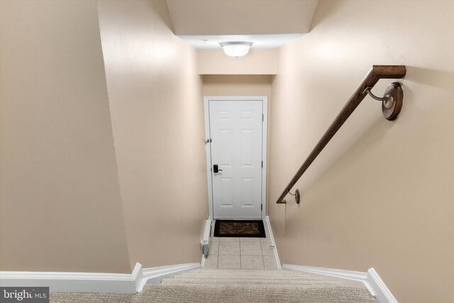 stairway featuring baseboards and tile patterned floors