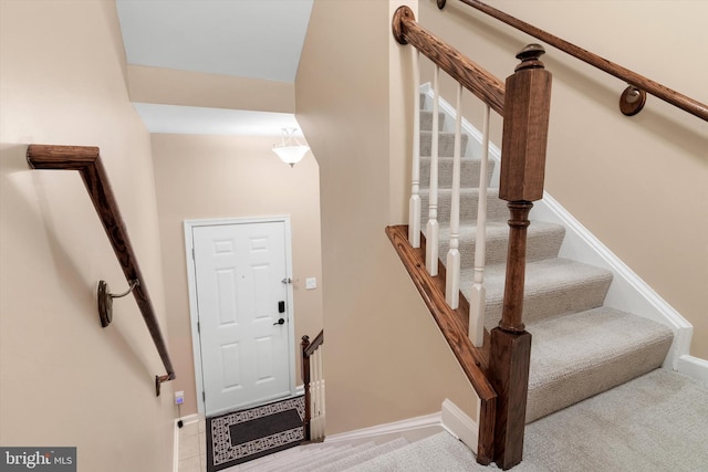 stairs with baseboards and carpet floors