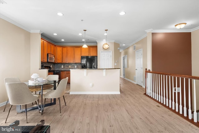 kitchen featuring light wood-type flooring, ornamental molding, backsplash, and black appliances