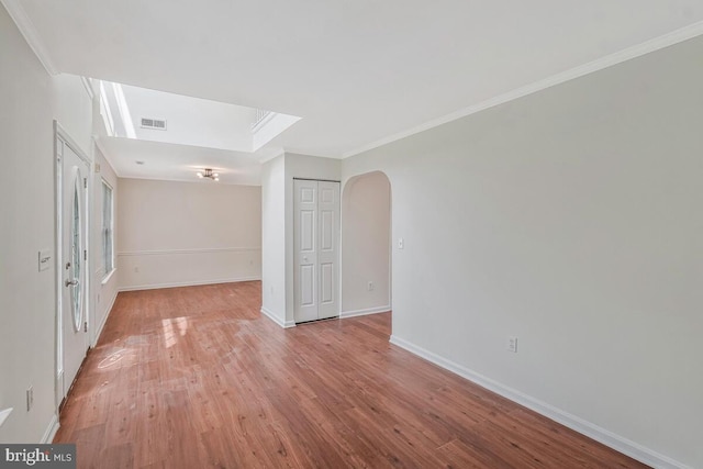 11620 Myrtle Oak Ct, Waldorf, MD 20601 - unfurnished room with light wood-style flooring, arched walkways, crown molding, baseboards, and a skylight