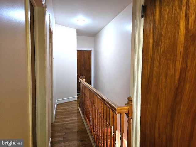 hallway with wood finished floors and an upstairs landing