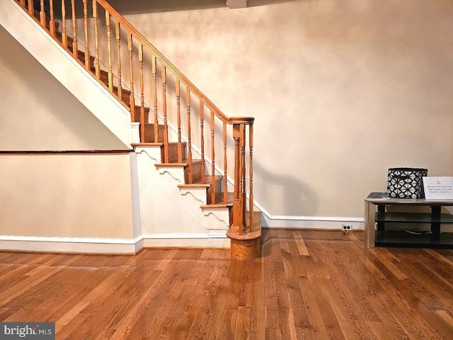 stairs with wood finished floors and baseboards