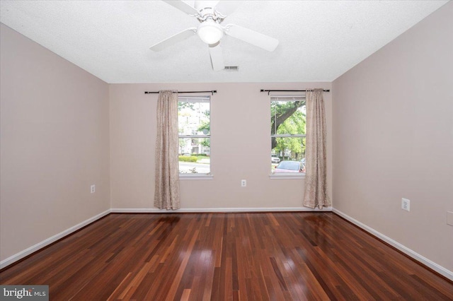 empty room featuring wood finished floors, a ceiling fan, visible vents, and baseboards