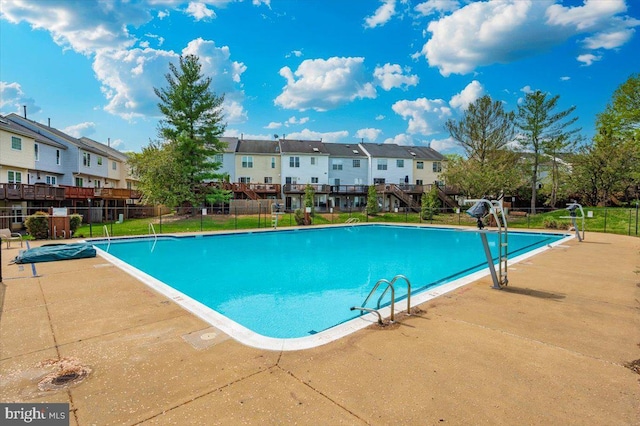 community pool with fence and a residential view