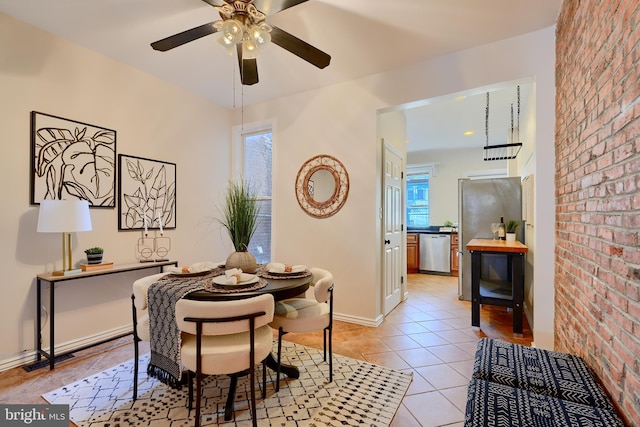 806 W 35th St, Baltimore, MD 21211 - dining space featuring brick wall, baseboards, ceiling fan, and light tile patterned flooring