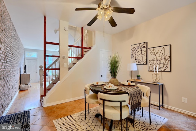 806 W 35th St, Baltimore, MD 21211 - tiled dining area featuring brick wall, baseboards, stairs, and ceiling fan