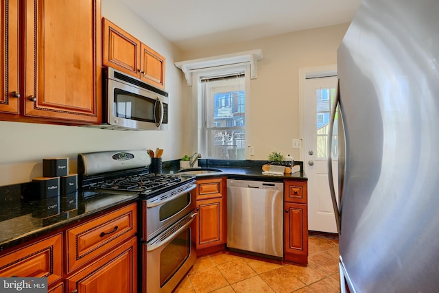 806 W 35th St, Baltimore, MD 21211 - kitchen with brown cabinets, appliances with stainless steel finishes, light tile patterned flooring, and a sink