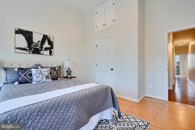 806 W 35th St, Baltimore, MD 21211 - bedroom with baseboards, a towering ceiling, and light wood-style flooring