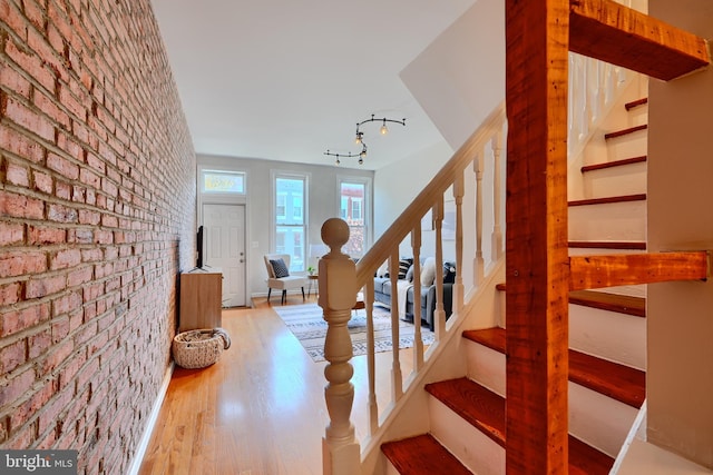806 W 35th St, Baltimore, MD 21211 - foyer featuring brick wall, wood finished floors, and stairs