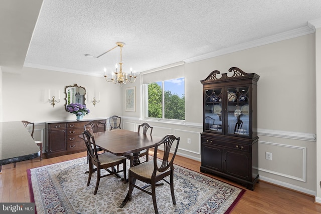 1515 S Arlington Ridge Rd Unit 402, Arlington, VA 22202 - dining area featuring an inviting chandelier, a textured ceiling, crown molding, and wood finished floors