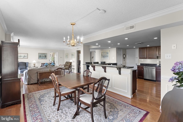 1515 S Arlington Ridge Rd Unit 402, Arlington, VA 22202 - dining area with visible vents, ornamental molding, an inviting chandelier, and light wood-style flooring