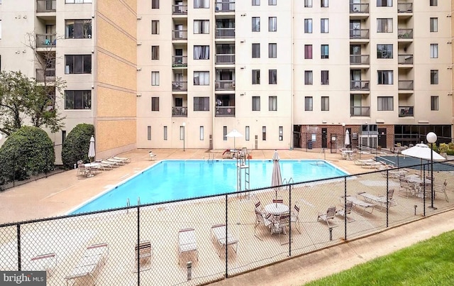 view of swimming pool with a patio area and fence