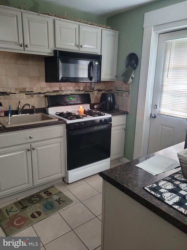 2027 Anchor St, Philadelphia, PA 19124 - kitchen with white cabinets, black microwave, range with gas stovetop, and backsplash