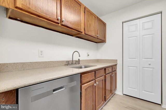 kitchen featuring a sink, brown cabinets, light wood-type flooring, light countertops, and dishwasher