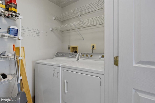 clothes washing area featuring washing machine and clothes dryer and laundry area