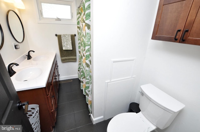 full bathroom with double vanity, tile patterned floors, toilet, and a sink