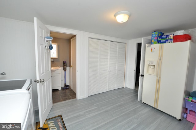 interior space with light wood-style floors and white refrigerator with ice dispenser