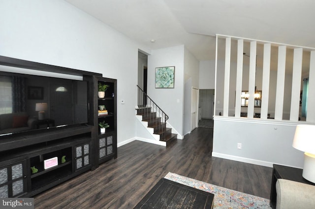 living area with baseboards, wood finished floors, and stairs