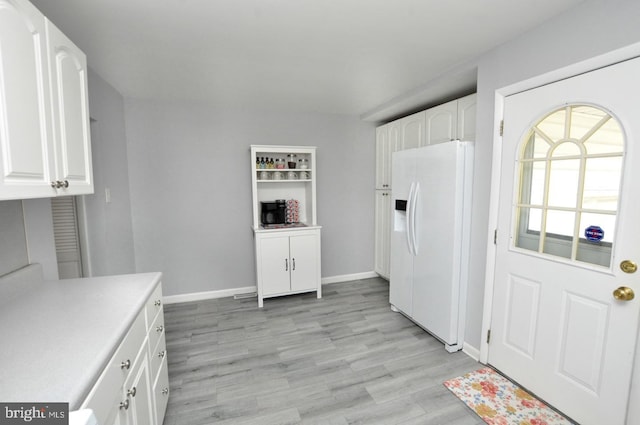 interior space with baseboards and light wood-style floors