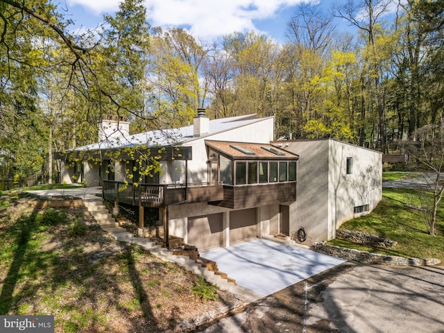 390 S Bryn Mawr Ave, Bryn Mawr, PA 19010 - exterior space featuring driveway, a chimney, and an attached garage
