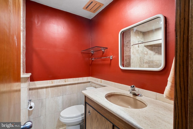 390 S Bryn Mawr Ave, Bryn Mawr, PA 19010 - bathroom featuring vanity, toilet, visible vents, wainscoting, and tile walls