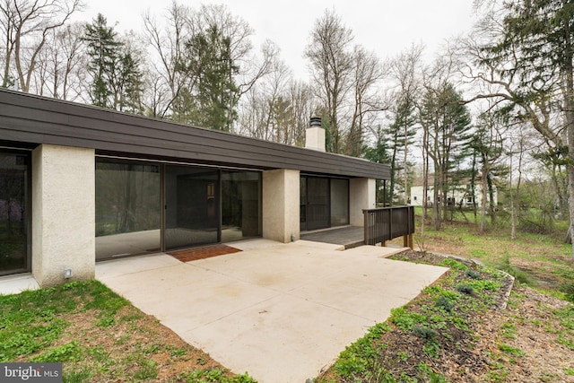 390 S Bryn Mawr Ave, Bryn Mawr, PA 19010 - rear view of property with a chimney, a patio area, and stucco siding