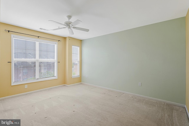 carpeted empty room featuring visible vents, baseboards, and ceiling fan