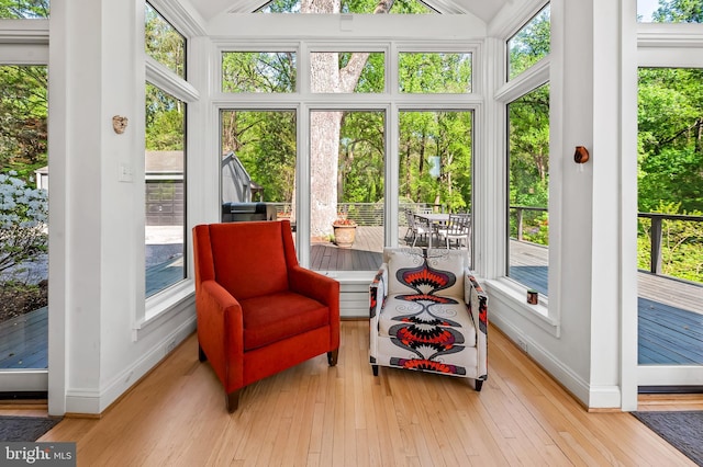 sunroom / solarium with baseboards, lofted ceiling, and a healthy amount of sunlight