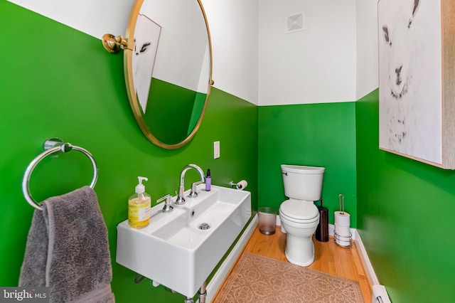 bathroom with visible vents, wood finished floors, a sink, baseboards, and toilet