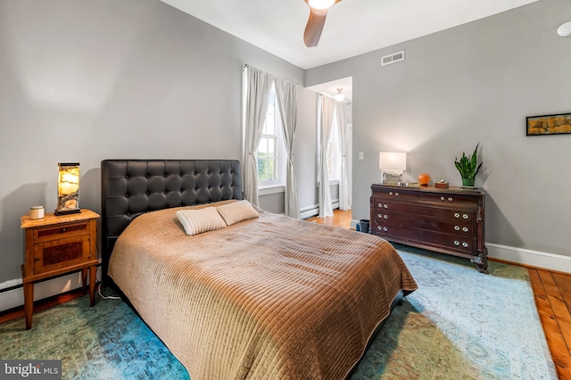 bedroom with visible vents, baseboards, ceiling fan, and wood finished floors