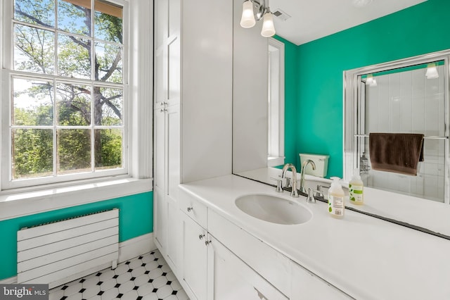 bathroom with plenty of natural light, radiator, visible vents, and vanity