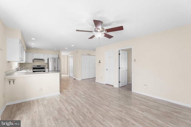unfurnished living room with baseboards, recessed lighting, a ceiling fan, light wood-style floors, and a sink