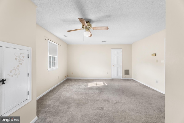 unfurnished room featuring baseboards, a ceiling fan, visible vents, and carpet floors