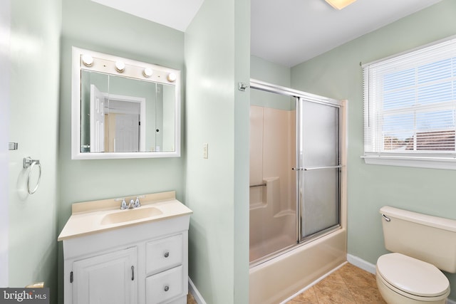 bathroom featuring baseboards, combined bath / shower with glass door, toilet, vanity, and tile patterned floors