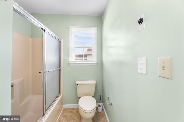bathroom with toilet, tile patterned floors, baseboards, and combined bath / shower with glass door