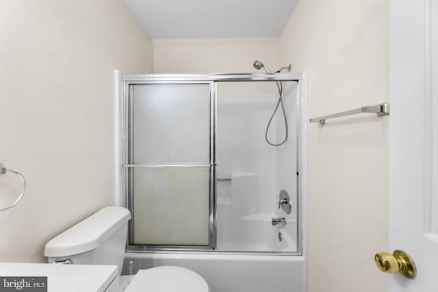bathroom with toilet, vanity, and bath / shower combo with glass door